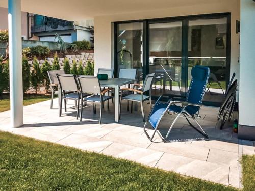a patio with chairs and a table on a patio at ZWEITE HEIMAT - Alpine Garden Retreat in Zillertal, presented by AlpenLuxus in Fügen