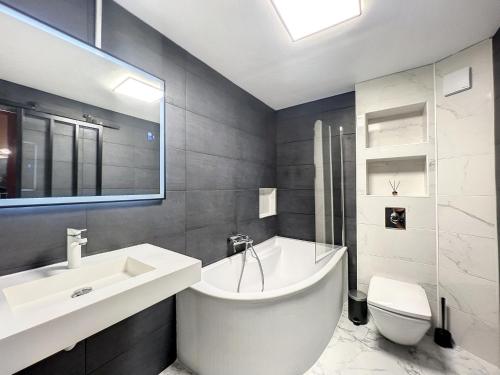 La salle de bains est pourvue d'une baignoire, d'un lavabo et de toilettes. dans l'établissement Eros, au Cap d'Agde