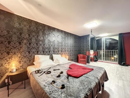 a bedroom with a bed with a red shirt on it at Eros in Cap d'Agde