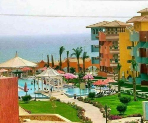a view of a resort with a swimming pool and the ocean at شاليهات بورتو ساوث بيتش عائلات in Ain Sokhna