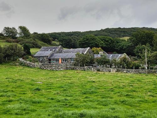 a stone house in the middle of a field at Ty Gwennol near Gilfach Goch in Llanbedr