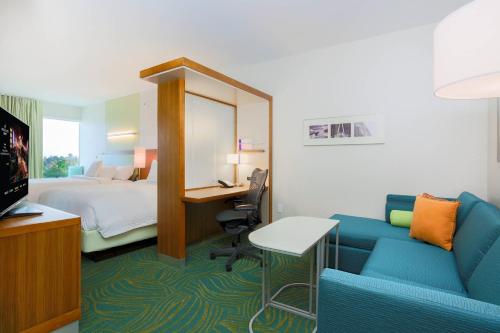 Cette chambre comprend un lit, un bureau et un canapé. dans l'établissement SpringHill Suites by Marriott San Jose Airport, à San José