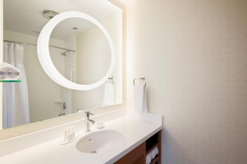Baño blanco con lavabo y espejo en SpringHill Suites by Marriott San Jose Airport en San José