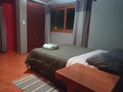 sypialnia z łóżkiem ze stołem i oknem w obiekcie Departamento amoblado amplio w mieście Huancayo