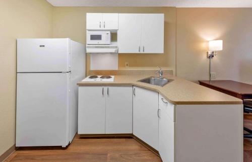 a kitchen with white cabinets and a white refrigerator at Extended Stay America Suites - Los Angeles - Valencia in Stevenson Ranch