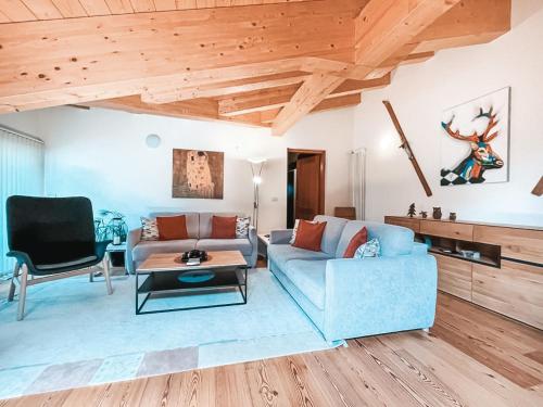 a living room with a blue couch and a table at AlpenLuxus' LUNA with relaxation room, sauna & car park in Seefeld in Tirol