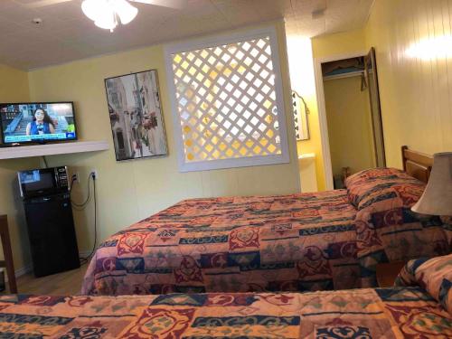 a hotel room with two beds and a television at Lakelawn B&B and Motel in Yarmouth