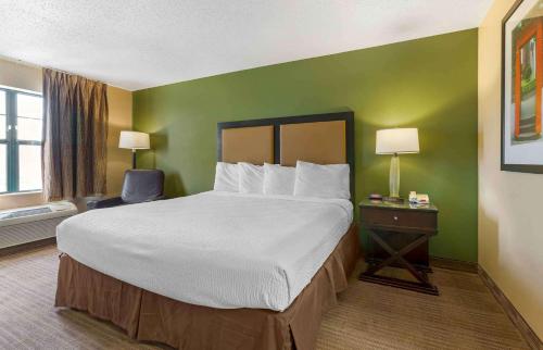 a hotel room with a large bed and a chair at Extended Stay America Suites - Albuquerque - Rio Rancho in Rio Rancho