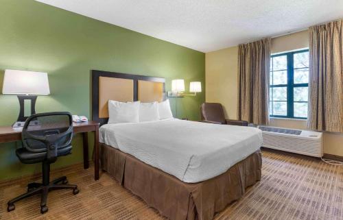 Cette chambre comprend un grand lit, un bureau et une chaise. dans l'établissement Extended Stay America Suites - Livermore - Airway Blvd, à Livermore