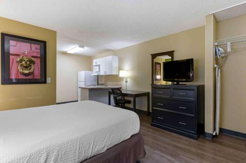 a hotel room with a bed and a flat screen tv at Extended Stay America Suites - Phoenix - Scottsdale - North in Scottsdale