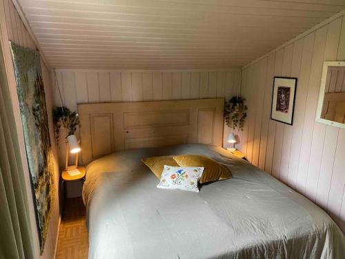 a small bedroom with a bed with two lamps at Romslig hytte nær R7, Ål sentrum, fjell & skianlegg in Liagardane