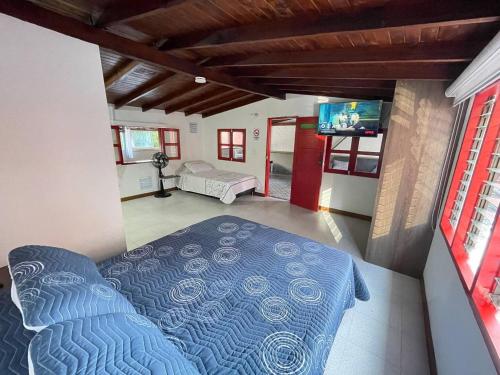 1 dormitorio con 1 cama azul y TV en Amplio e iluminado 74 m2 Wf 200 MB ideal mascotas, en Sabaneta
