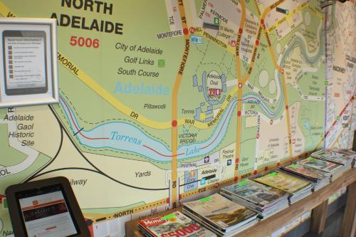 a wall with a map and a tablet and books at North Adelaide Boutique Stays Accommodation in Adelaide