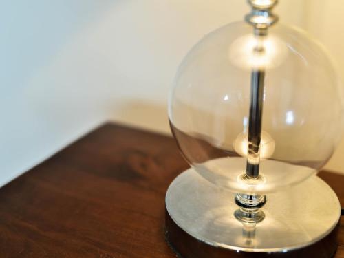 a glass lamp sitting on top of a wooden table at Beausejour Guest House in Pointe-Noire