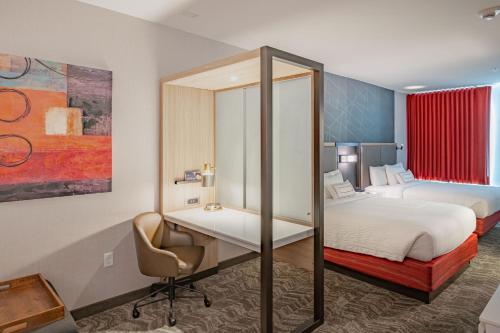 a bedroom with a bed and a desk with a chair at SpringHill Suites Dallas Central Expressway in Dallas