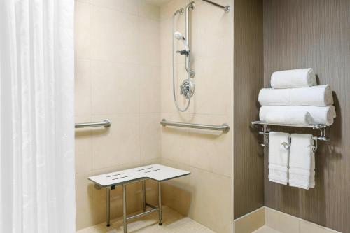 a bathroom with a shower and a stool with towels at Sheraton Baltimore North in Towson