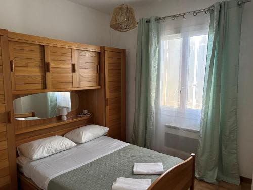 une chambre avec un lit, un miroir et une fenêtre dans l'établissement Provencal style home in Mediterranean seaside town, à La Londe-les-Maures