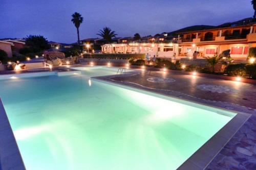 una grande piscina notturna con luci di Casa Marco a Golfo Aranci