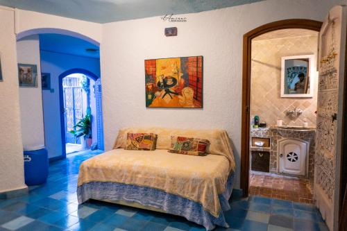 a bedroom with a bed and a painting on the wall at DAR DAUIA in Chefchaouen