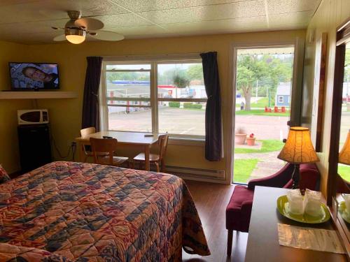 a bedroom with a bed and a table and a window at Lakelawn B&B and Motel in Yarmouth