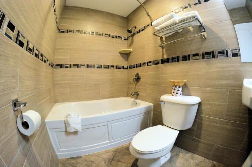 łazienka z wanną, toaletą i umywalką w obiekcie Sunset Motel w mieście Santa Barbara