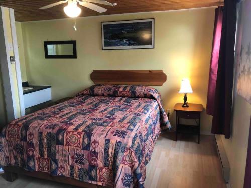 a bedroom with a bed and a table with a lamp at Lakelawn B&B and Motel in Yarmouth