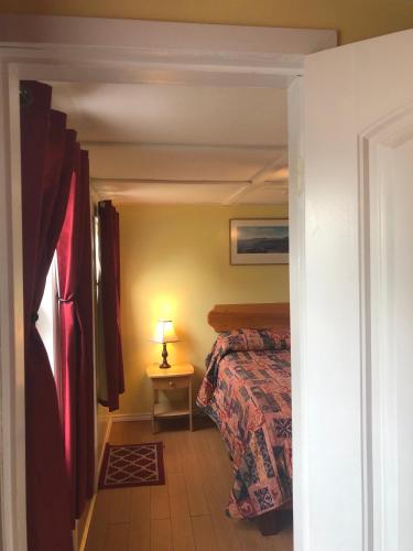 a bedroom with a bed and a lamp on a table at Lakelawn B&B and Motel in Yarmouth