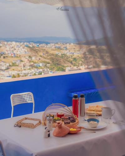 a table with food and a view of a city at DAR DAUIA in Chefchaouene