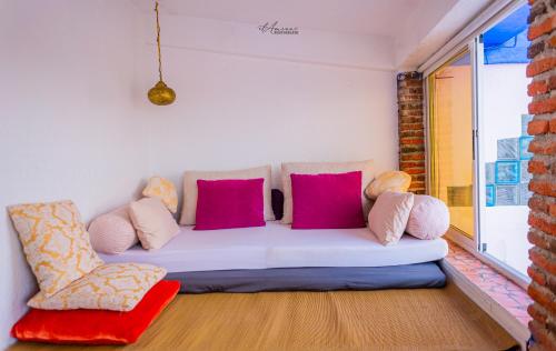 a couch in a room with pink and purple pillows at DAR DAUIA in Chefchaouene