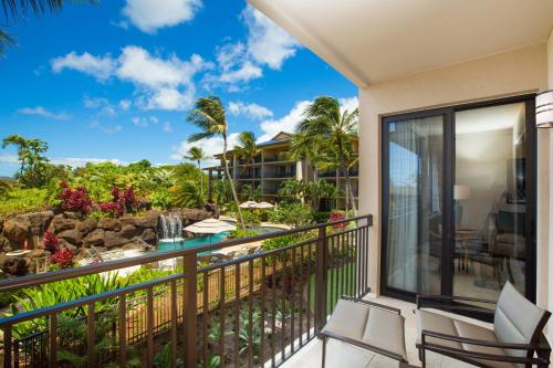 a balcony with chairs and a view of a resort at Koloa Landing Resort at Po'ipu, Autograph Collection in Koloa