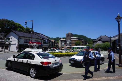 a group of police officers standing next to a police car at Morizuya in Toyooka