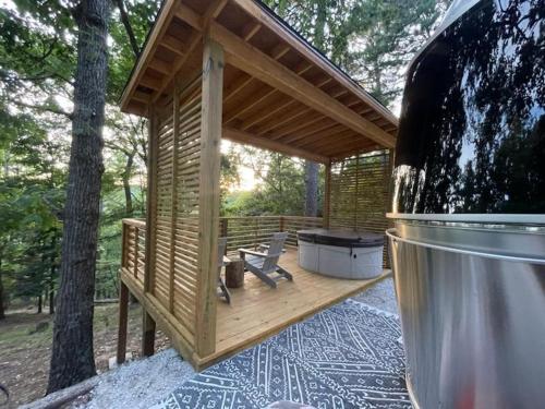 Cabaña de madera pequeña con parrilla en la cubierta en Airstream Caravel 2020 Loblolly Pines Adventure Camp en Eureka Springs