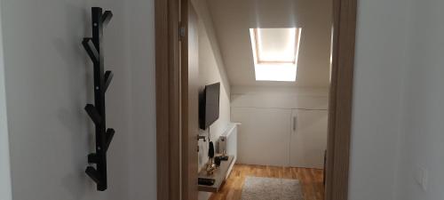 um corredor com uma clarabóia e uma porta para um quarto em Apartman Blagojevic Hill em Arandjelovac