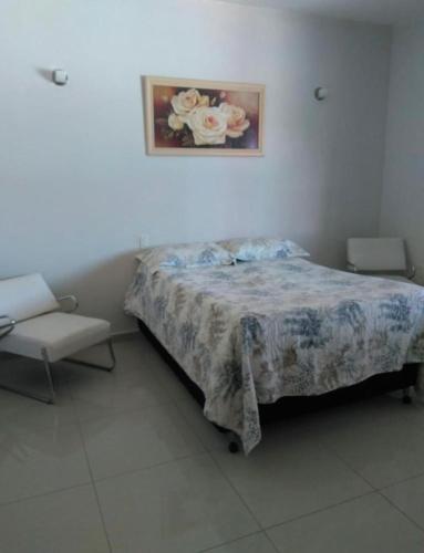 sypialnia z łóżkiem i zdjęciem na ścianie w obiekcie Casa Condomínio Arraial do Cabo w mieście Arraial do Cabo