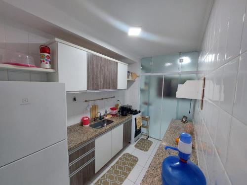 Apartamento Peruíbe في بيرويبي: مطبخ صغير مع مغسلة وثلاجة