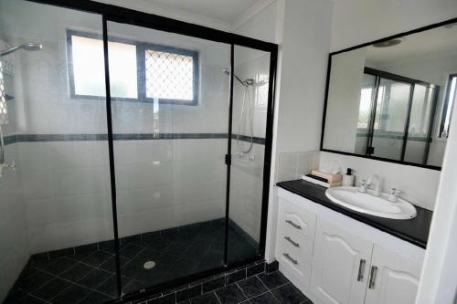 La salle de bains est pourvue d'une douche et d'un lavabo. dans l'établissement Studio Apartment, à Bargara