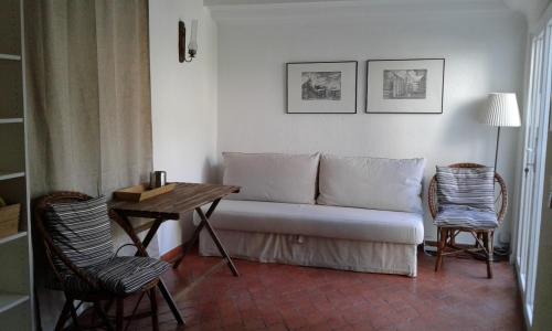 a living room with a couch and a table and chairs at Sunny and cozy room close to Cascais center in Cascais