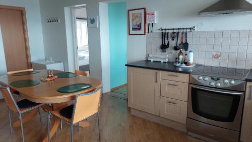 - une cuisine avec une table en bois, une table et une cuisinière dans l'établissement Olafsvik Guesthouse, à Ólafsvík