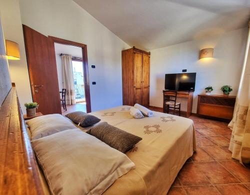 a bedroom with two beds and a flat screen tv at Domos de Ammentos in Tortolì