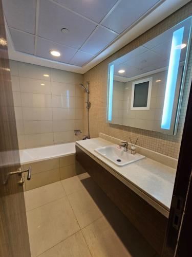 a bathroom with a sink and a tub and a mirror at SKY 9 Hostel in Dubai