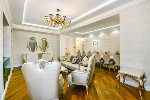 un salón con sillas blancas y una lámpara de araña en Nizami Street VIP Apartment en Bakú