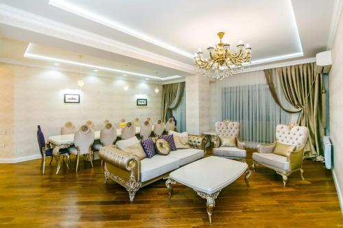Nizami Street VIP Apartment في باكو: غرفة كبيرة مع أريكة وطاولة وكراسي
