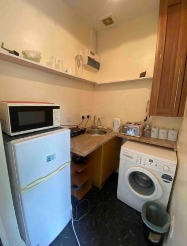 a kitchen with a washing machine and a microwave at RHB Apartments in Leicester