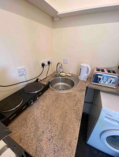 a small kitchen with a sink and a stove at RHB Apartments in Leicester