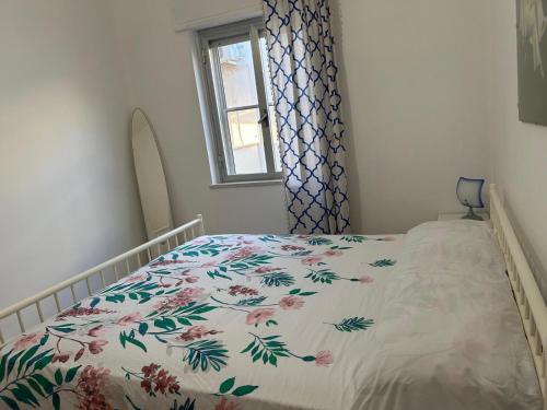 Il mare che ti Puglia في جينوسا مارينا: غرفة نوم مع سرير مع لحاف متهالك