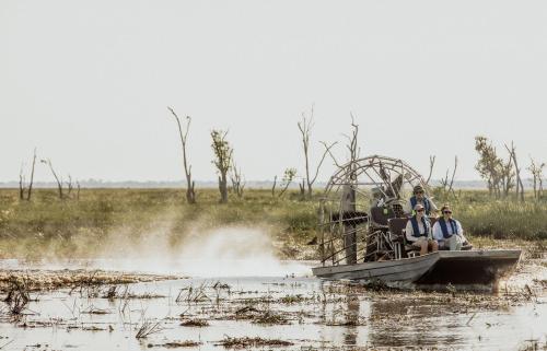 a group of people sitting on a boat in the water at Bamurru Plains in Point Stuart