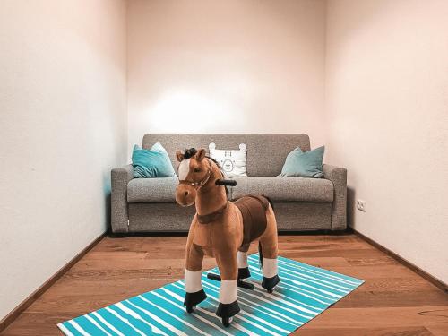 a toy horse standing on a rug in a living room at CLOUD 9 - Penthouse with Private Rooftop Whirlpool & Terrace in Zillertal, presented by AlpenLuxus in Fügen