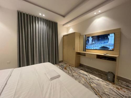 Habitación de hotel con cama y TV en سويت إم للأجنحة الفندقية en AR Rummanah