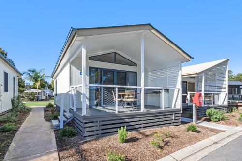 a manufactured home with a porch and a deck at Reflections Ferry Reserve - Holiday Park in Brunswick Heads