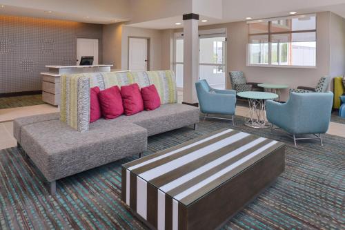 een lobby met een bank en een tafel en stoelen bij Residence Inn by Marriott Cedar Rapids South in Cedar Rapids